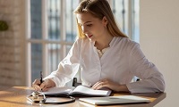 woman sitting writing in a book