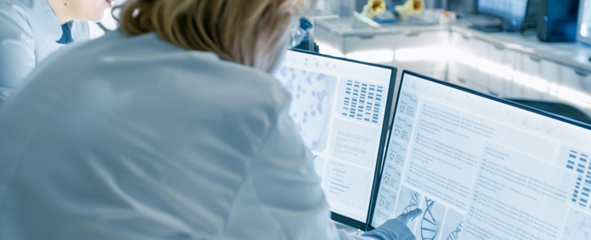 female physicians looking at two computer screens with data