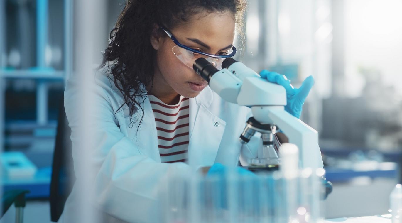 female physician looking through a microscope