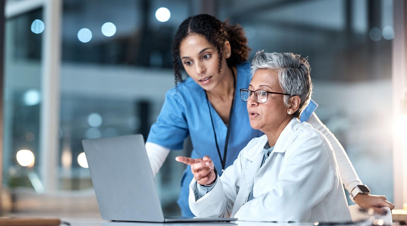 two physicians looking at a laptop screen