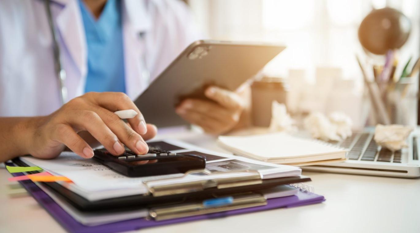 physician using tablet and calculator