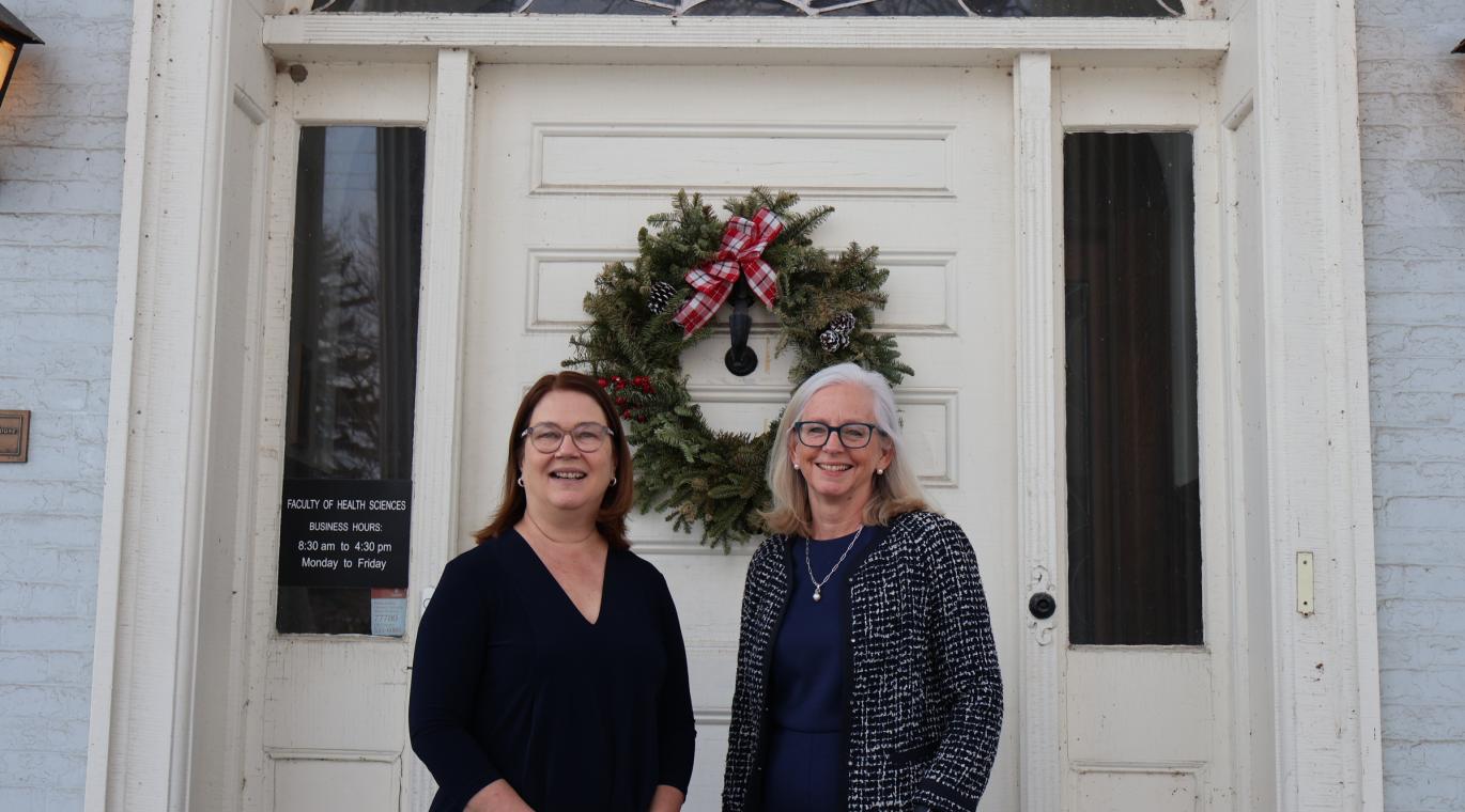 photo of Drs. Jane Philpott and Diane Lougheed in front of a building