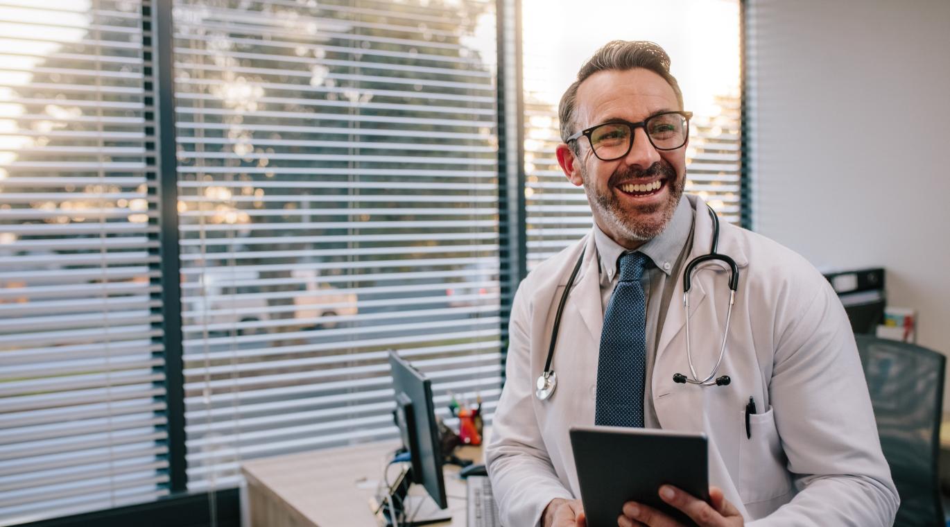 male physician holding a tablet