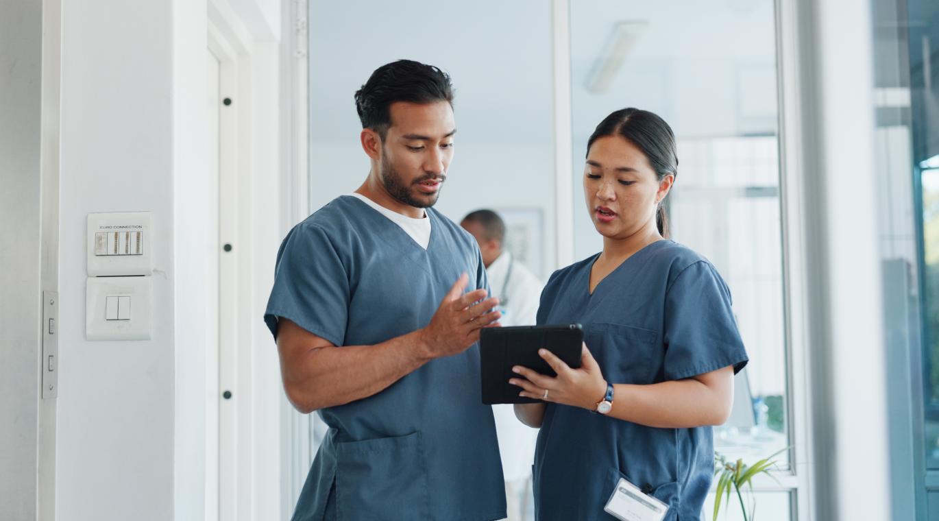 two physicians looking at a tablet