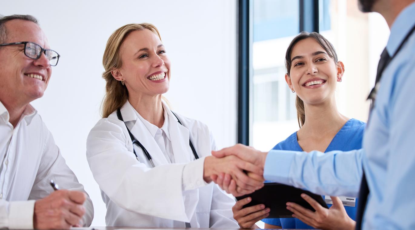 female physician shaking hands with male physician