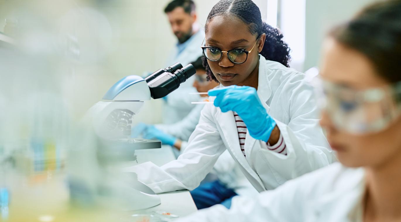 female physician using a microscope