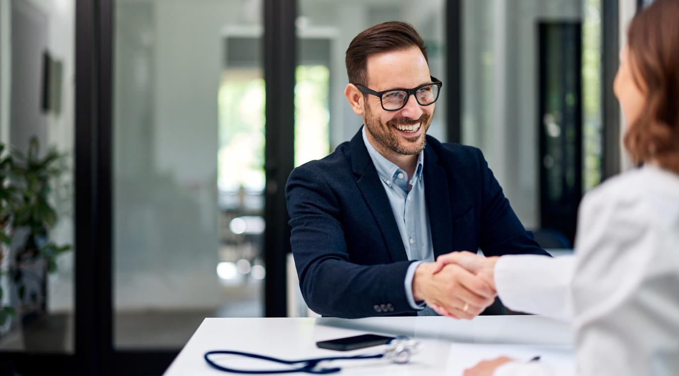 male candidate shaking hands with female physician