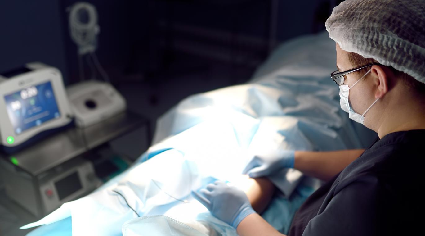 Professional vascular surgeon is in the operating room of the clinic during vein surgery.