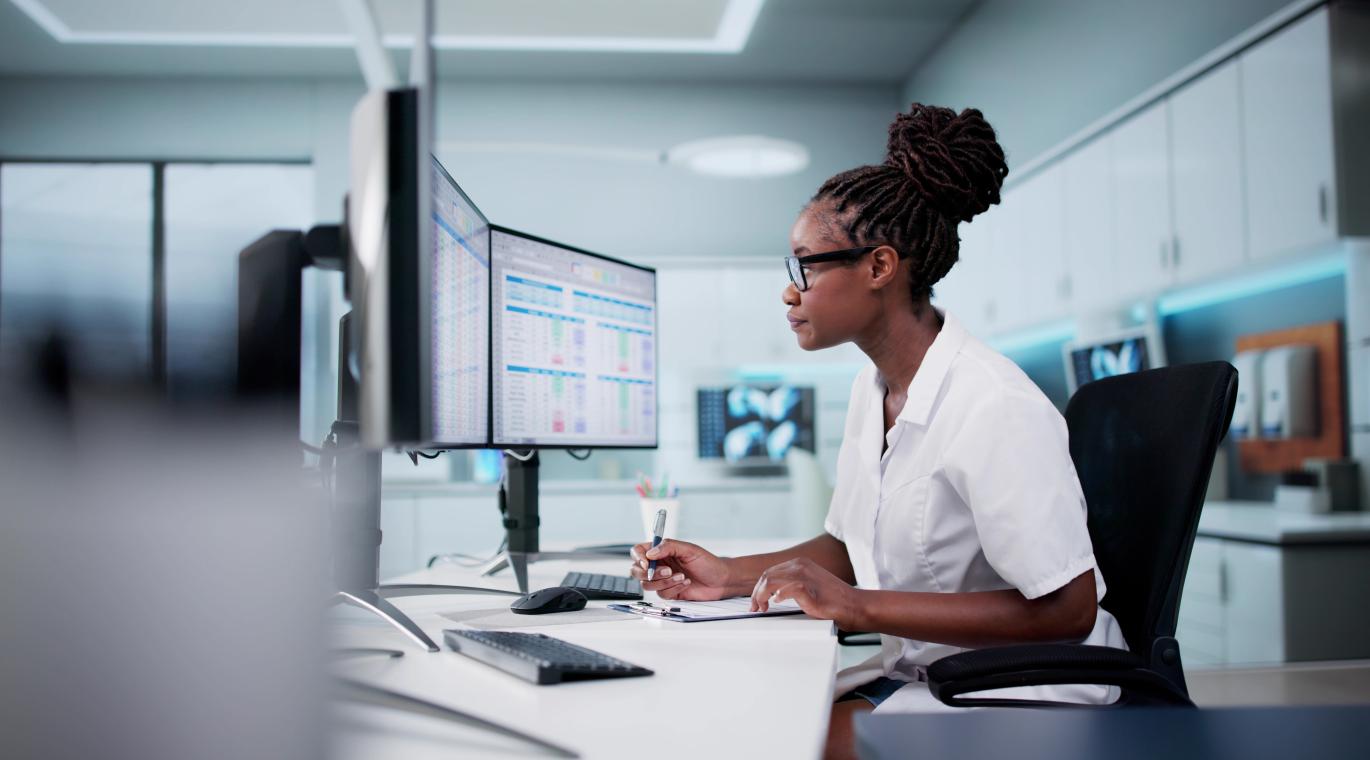 Hospital Doctor Using Spreadsheet For Billing Codes On Desktop