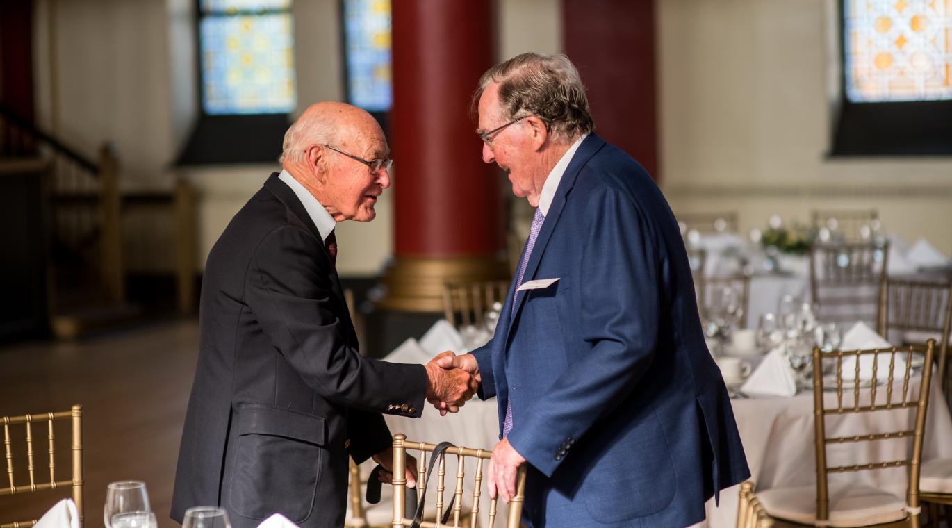 Duncan Sinclair shaking a man's hand