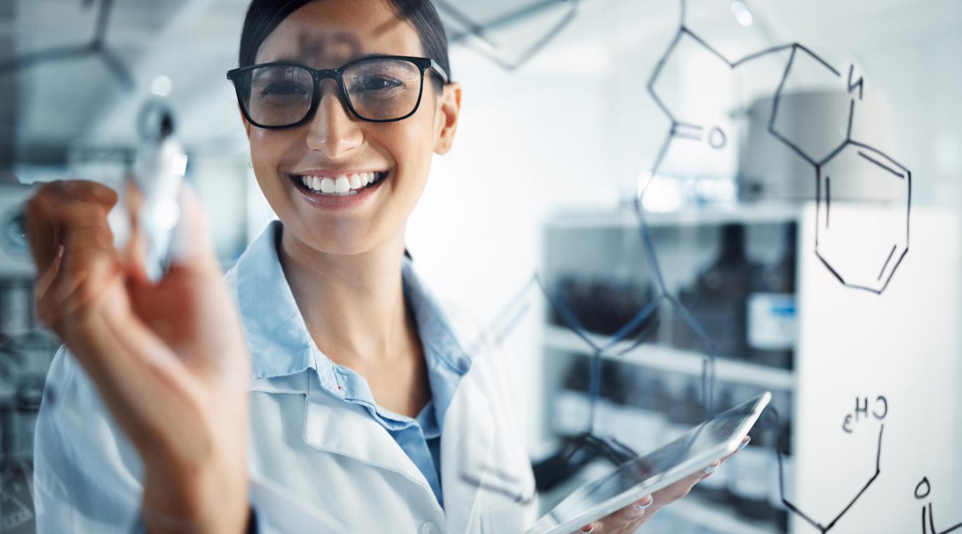 female researcher writing on clear board