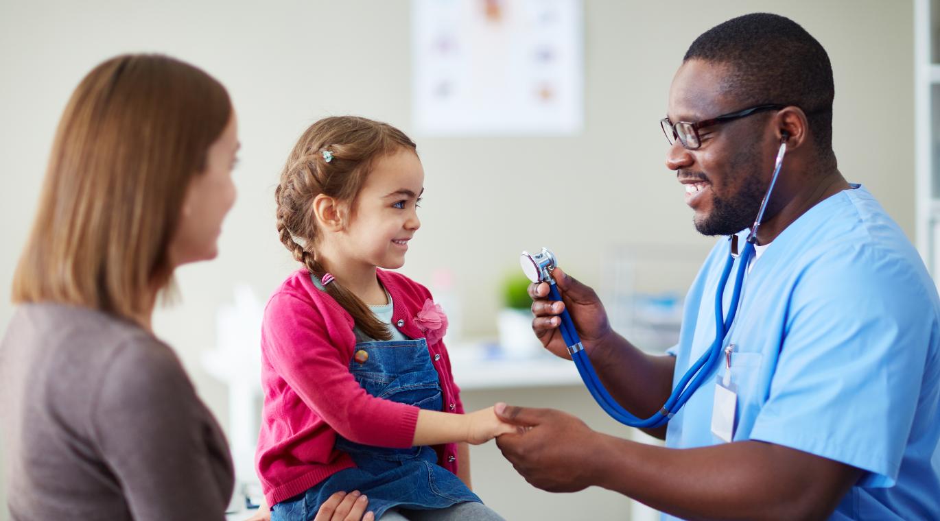 Doctor doing a check up on a little girl with her mom