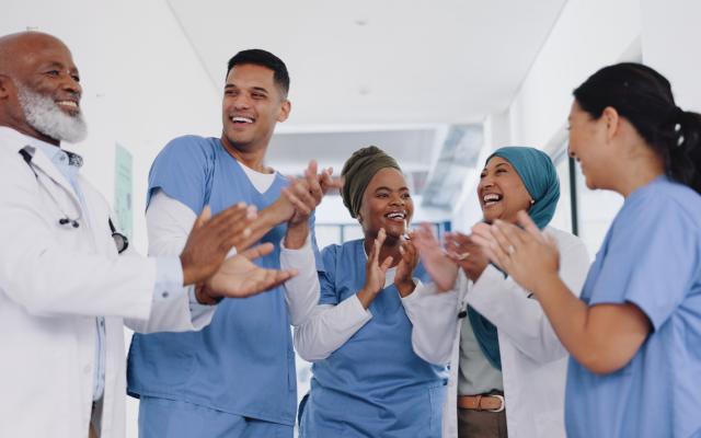 group of physicians celebrating and clapping