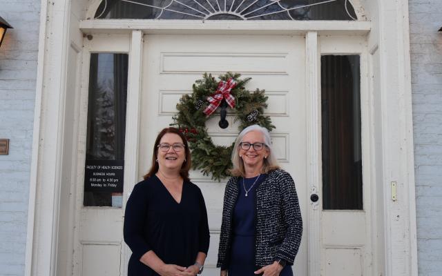 photo of Drs. Jane Philpott and Diane Lougheed in front of a building