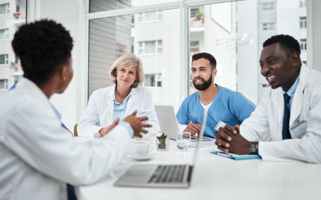 Doctor, team and happy with meeting in boardroom for healthcare diagnosis, surgery planning and medical workshop. 