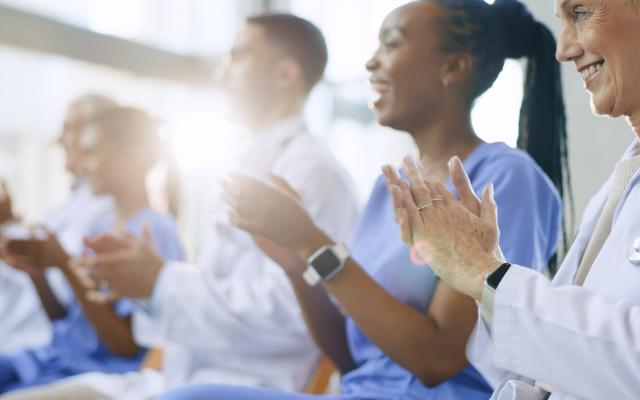 Doctors, happy and applause for celebration in conference with healthcare, presentation or medical results in hospital meeting or workshop.