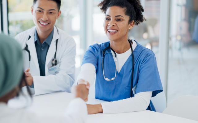 Doctors handshake, welcome and hospital team with applause, onboarding and kindness for new colleagues. 