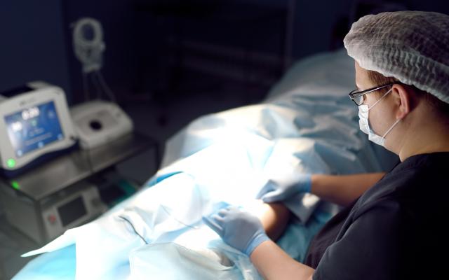 Professional vascular surgeon is in the operating room of the clinic during vein surgery.