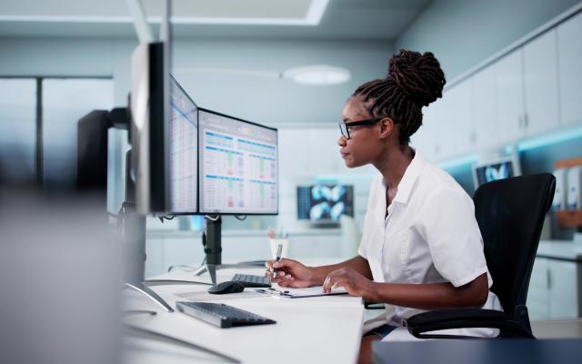 Hospital Doctor Using Spreadsheet For Billing Codes On Desktop