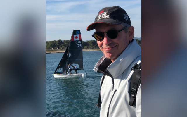 Dr ten Hove on the water with a sailboat in the background