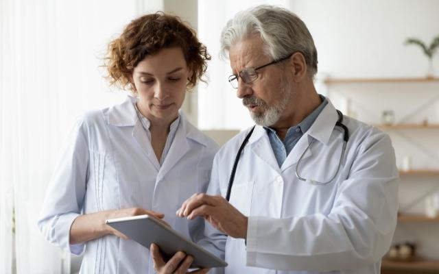physicians talking while looking at tablet