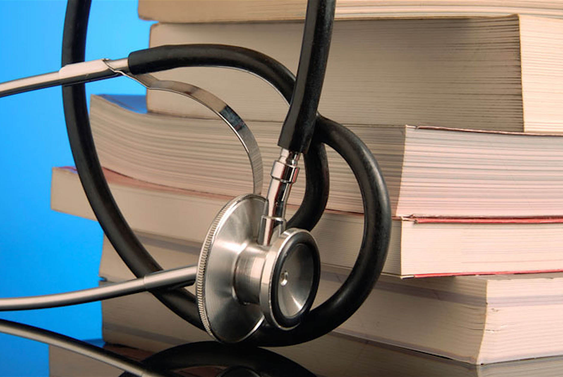 stethoscope leaning against stack of books