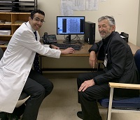 Photo of Dr. Almufleh and Dr. Abdollah sitting around a computer