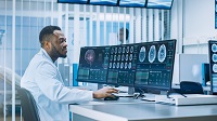 doctor staring at brain scans on a screen