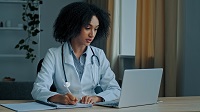 physician looking at laptop